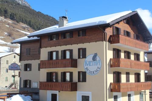 a building with a sign on the side of it at Residence Raethia tra Bormio e Livigno in Valdidentro