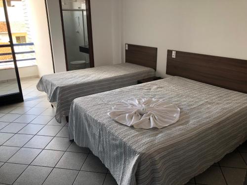 two beds in a hotel room with a bow on them at Hotel Kalilândia in Feira de Santana