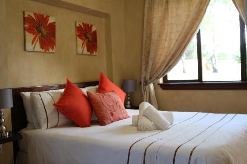 米德蘭的住宿－La Villa Rosa，一间卧室配有红色和白色枕头的床