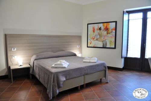 una camera da letto con un letto e un dipinto sul muro di La Dimora del Musicante HomeGallery a Viggiano