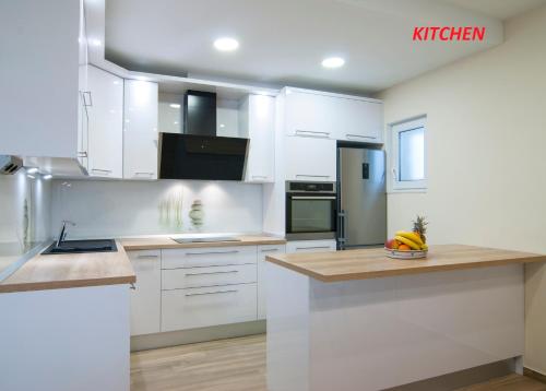 a kitchen with white cabinets and a counter top at Apartments Lokva in Lokva Rogoznica