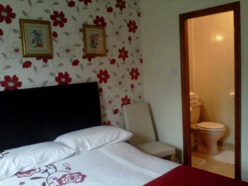 una camera con letto, servizi igienici e specchio di Prince Charlie's Cottage a Gretna Green