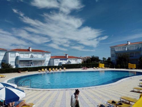 a woman walking by a swimming pool in a resort at Apartment Oásis Comfort in Portimão