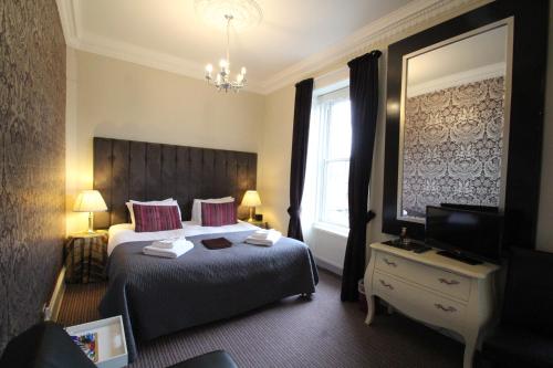 a hotel room with a bed and a television at The Sandaig in Edinburgh