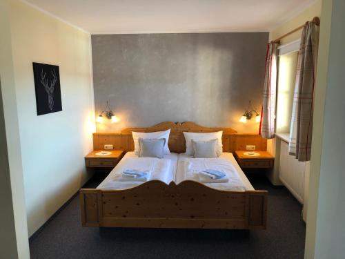 a bedroom with a large wooden bed with two tables at Landhaus Sonnenbichl in Oy-Mittelberg