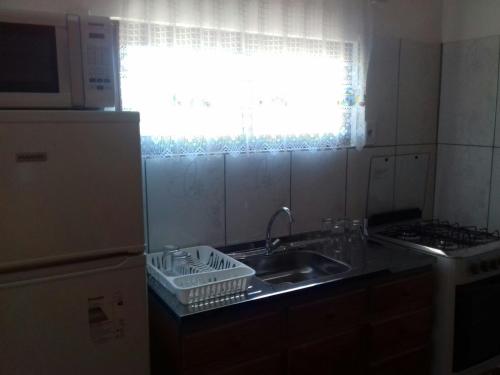 a small kitchen with a sink and a window at Sonidos del Mar in Punta Del Diablo