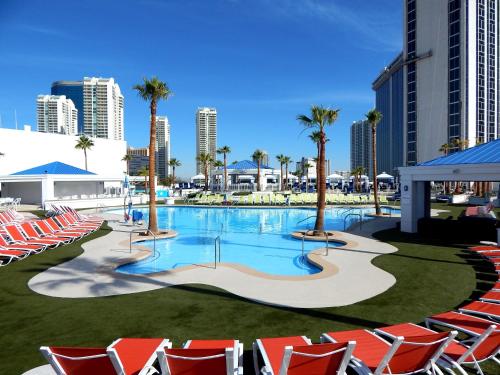 a large swimming pool with red chairs and palm trees at Westgate Las Vegas Resort and Casino in Las Vegas