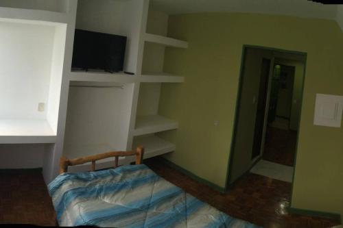 a bedroom with a bed and a tv and shelves at Beautiful Apartment San Jose Downtown South in San José