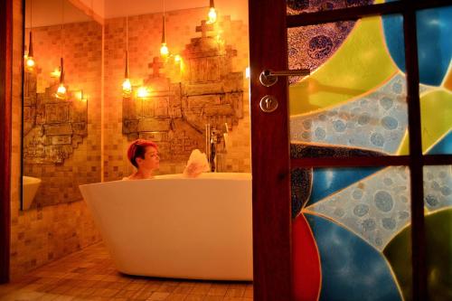 una mujer sentada en una bañera en un baño en Mama Cuchara by Art Hotels, en Quito