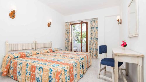 a bedroom with a bed and a table and a desk at Hostal San Francisco in Cala d´Or