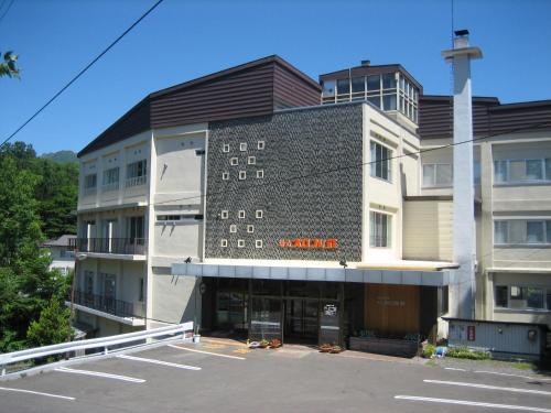 a building with a parking lot in front of it at Karurusu Onsen Yumoto Orofuresou in Noboribetsu