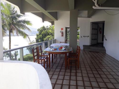 a patio with a table and chairs on a balcony at VISTA DESLUMBRANTE APTO 709 in Ubatuba
