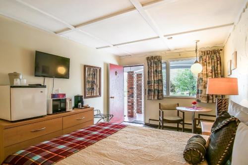una camera da letto con un letto, una tv e un tavolo di Gables Motel a Radium Hot Springs