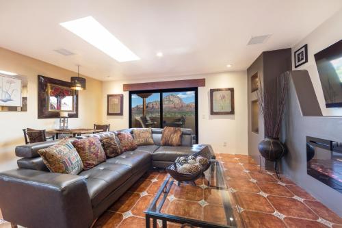 a living room with a leather couch and a table at A Sunset Chateau in Sedona