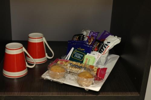 a table with a tray of donuts and cups at Eclat Suites Hotel Boutique in Villa Mercedes