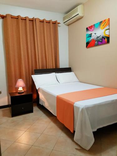 a bedroom with a bed with an orange curtain at Abrico Apartment in Trou aux Biches