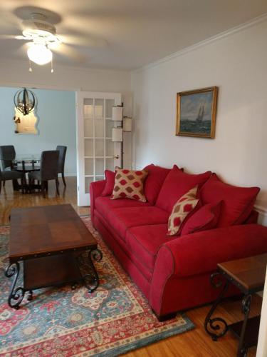 a living room with a red couch and a table at University City Guest House in Charlotte