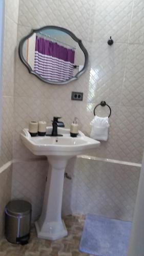a white bathroom with a sink and a mirror at Bailey's Bed and Breakfast in Runaway Bay