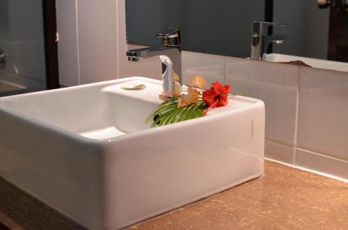 a white sink with a flower in it in a bathroom at Grand West Villas in Nadi