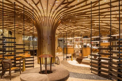 a large room with a wooden ceiling and tables and chairs at MGM Cotai in Macau