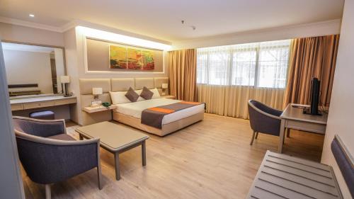 een hotelkamer met een bed en een bureau bij Kingwood Hotel Kuching in Kuching