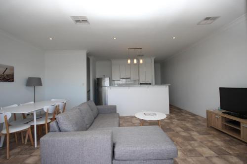 a living room with a couch and a table and a kitchen at Wallaroo Marina Apartments in Wallaroo
