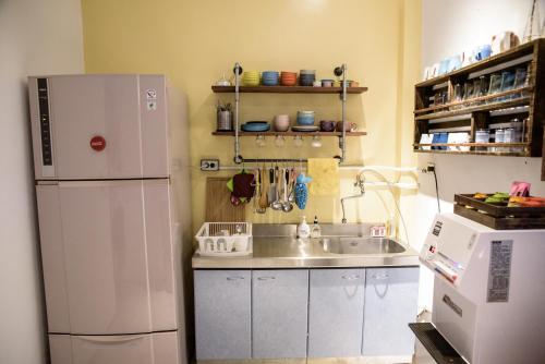 a kitchen with a white refrigerator and a sink at 框框背包客棧 Kuang Kuang Hostel in Longjing