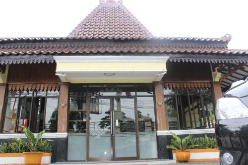 a building with glass windows and a roof at Simpang Tujuh in Cepu