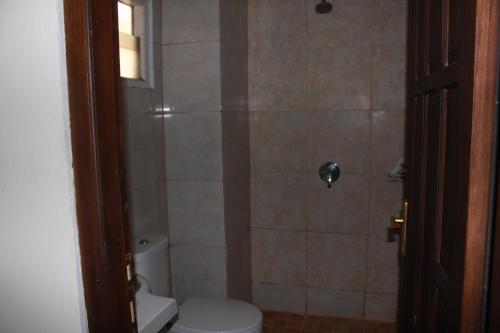 a bathroom with a shower with a toilet in it at Simpang Tujuh in Cepu