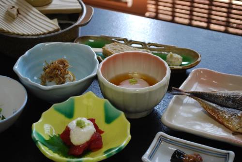 a table topped with bowls filled with food at Hakone Suimeisou in Hakone