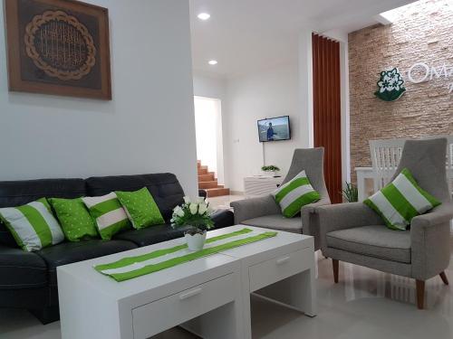 a living room with a couch and chairs and a table at Omah Melati - Vacation Home in Solo