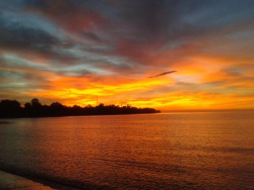 a sunset over a body of water at Sunset Cottages in Hitokalak