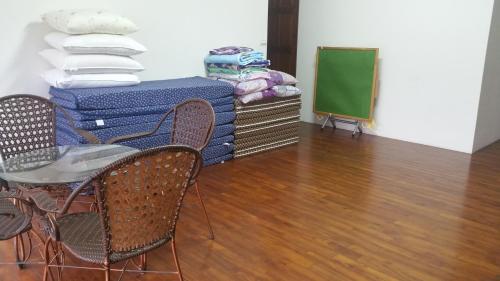 a room with chairs and stacks of mattresses at A-Ma Homestay in Fengli
