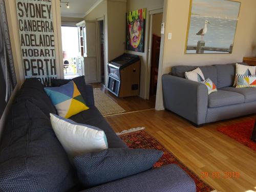 a living room with a couch and a television at Beach Buoy Opossum Bay in South Arm