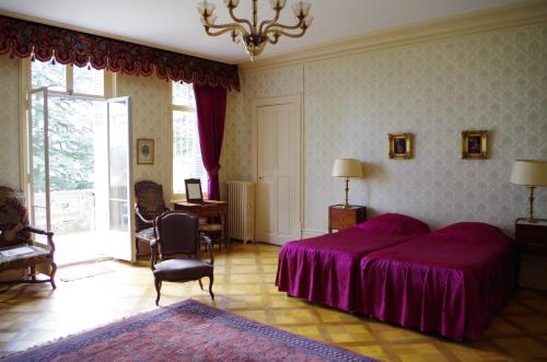 1 dormitorio con 1 cama con manta morada en Chateau de Varambon, en Varambon