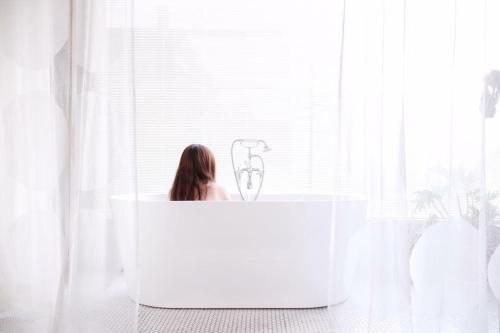 a woman sitting in a tub in front of a window at Kenting Sun Light Inn in Eluan