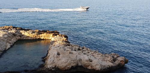 a boat in the ocean next to a rock formation at Il sogno di Ele in Polignano a Mare