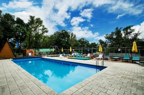 - une piscine avec des chaises longues et des parasols dans l'établissement Dubrava Park-Hotel, à Samara