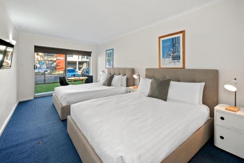 a hotel room with two beds and a window at North Pier Hotel in Cowes