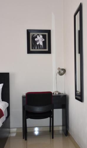 a bedroom with a desk and a chair and a mirror at Magville Guest House in Gaborone
