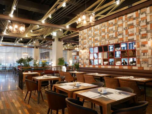 a dining room with wooden tables and chairs at Golden Tulip Incheon Airport Hotel in Incheon