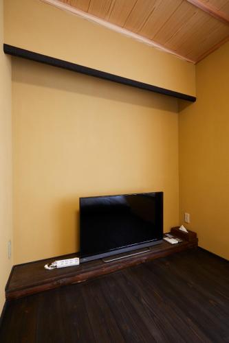 a large flat screen tv sitting on a wall at Miro Hachijo Uchidacho Tei in Kyoto