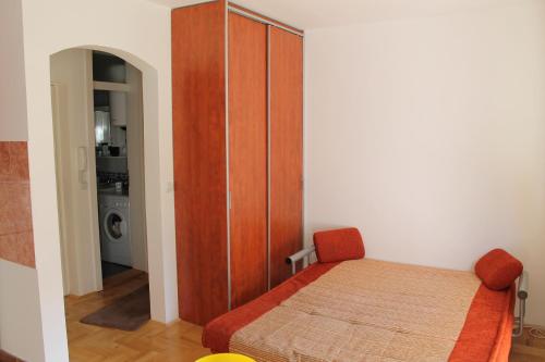 a bedroom with a bed and a wooden cabinet at Calm Apartment in Belgrade