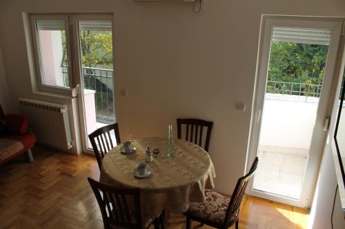 una sala da pranzo con tavolo, sedie e porta di Calm Apartment a Belgrado