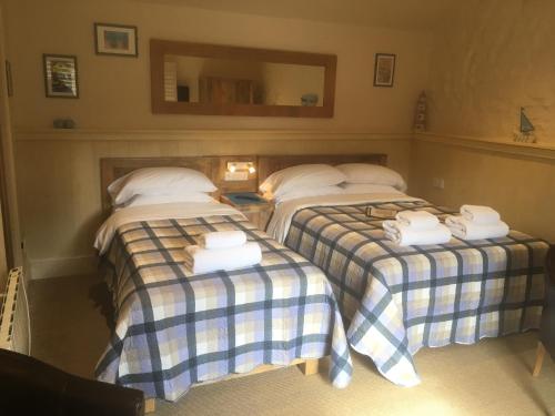 three beds in a room with towels on them at Widbrook Barns in Bradford on Avon