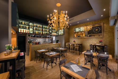 a restaurant with tables and chairs and a chandelier at Piazza Heritage Hotel in Split