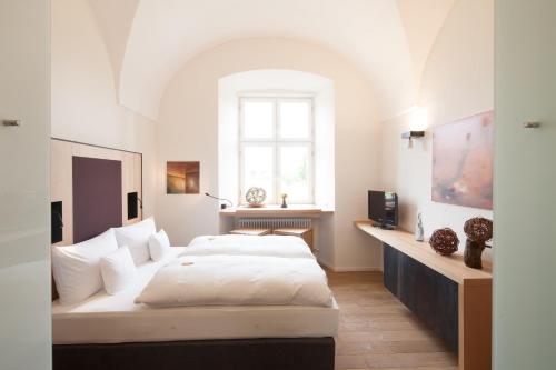 a bedroom with two beds and a window at Hotel Kloster Holzen in Allmannshofen