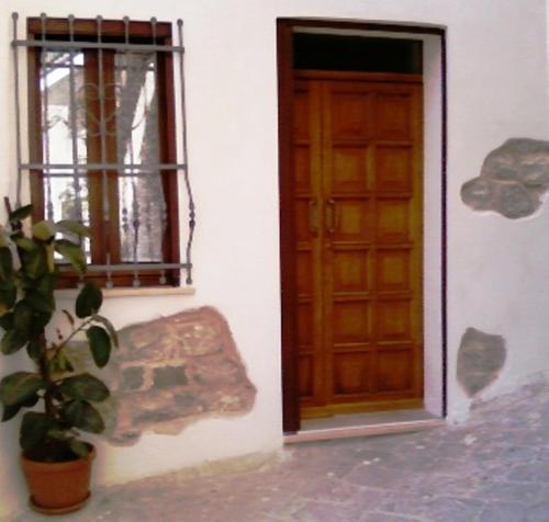 a door and a potted plant next to a window at La Mia Casa Sulla Collina in Valsinni
