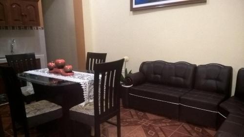 a living room with a table and a couch at Alojamiento El Cardenal in Iquitos