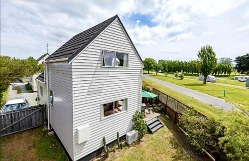 a small house with a black roof at Seaside Tahuna in Nelson